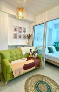 a living room with a green couch and a bed at AZURE Urban Resort Residences Condominium in Manila