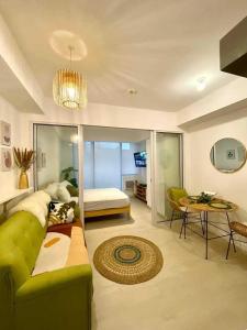 a living room with a green couch and a table at AZURE Urban Resort Residences Condominium in Manila