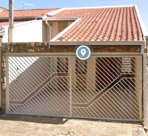 a wooden gate with a sign on it in front of a house at Quarto Divas na Sakura House in Indaiatuba