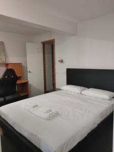 a bedroom with a bed with two towels on it at DingDing's downst-airs yellow House in Sandy Bay