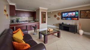 a living room with a couch and a tv at 2 Sleeper SEA VIEWS Apartment -- Near MSC Cruise Terminal in Durban