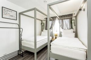 Unique Vintage Apartments في Goodmayes: غرفة نوم مع سريرين بطابقين ومرآة