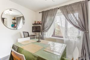 a dining room with a table and a mirror at Unique Vintage Apartments in Goodmayes
