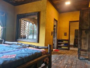 ein Schlafzimmer mit einem Bett und einem Spiegel in einem Zimmer in der Unterkunft Quan Din Ngai Villa in Dồng Văn