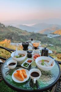 เหนือดอย แคมป์ปิ้ง ( Nuea Doi Camping ) في Ban Dong: صينية طعام على طاولة مع صحون طعام