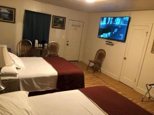 a hotel room with two beds and a flat screen tv at Angeles Motel in Port Angeles