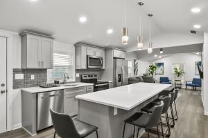 a kitchen with a white counter and chairs in it at Spacious & Charming House in Heart of Atlanta in Atlanta