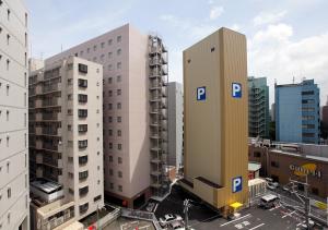 a tall white building in a city with buildings at Daiwa Roynet Hotel Hakata-Gion in Fukuoka