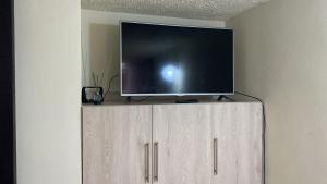 a flat screen tv sitting on top of a cabinet at Apartamento Madrid Cundinamarca in Madrid