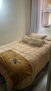 uma cama com um controlo remoto por cima em Apartamento Madrid Cundinamarca em Madrid