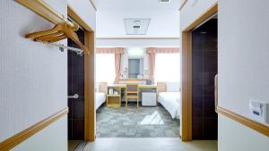 un couloir avec une chambre et une table dans l'établissement Toyoko Inn Kagoshima Temmonkan No 1, à Kagoshima