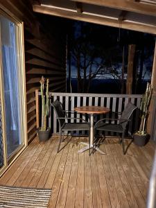 a wooden porch with a table and chairs on a deck at Tambaridge Bed & Breakfast in Eagle Heights