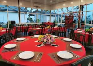 uma sala de jantar com uma mesa vermelha com pratos e guardanapos em D View Holiday Homes em Kudat