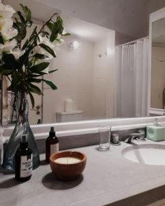 a bathroom with a sink and a vase of flowers at Casa Blanca in Colonia del Sacramento
