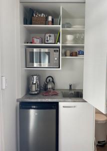 a kitchen with a sink and a microwave at Pickmere Waters in Kerikeri