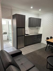 a living room with a couch and a kitchen at Blue Violet Motor Inn in Toowoomba