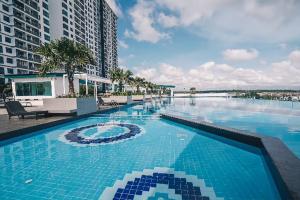 a large swimming pool with blue water in front of a building at D'Secret Tropika - 2 Bedrooms 4 Pax, Free Parking in Johor Bahru