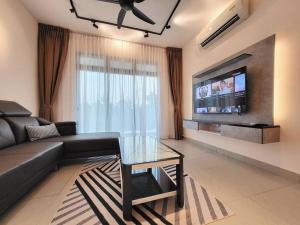 a living room with a couch and a tv at D'Secret Tropika - 2 Bedrooms 4 Pax, Free Parking in Johor Bahru