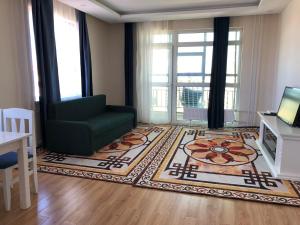 a living room with a green chair and a rug at Eagle Town Serviced Apartment- Free Pick up from Airport in Ulaanbaatar