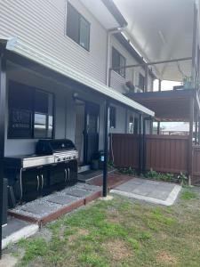 una casa con una parrilla en el patio delantero en River Heads K'Gari Fraser Island Adventure, en River Heads