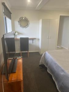 1 dormitorio con cama, escritorio y mesa en River Heads K'Gari Fraser Island Adventure, en River Heads