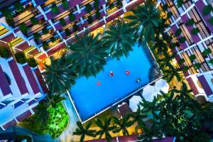 een uitzicht over een zwembad met palmbomen bij Hadana Boutique Resort HoiAn - former Belle Maison Hadana HoiAn in Hội An