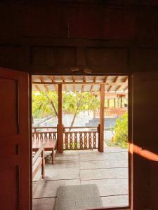 una puerta abierta a un porche con un banco en Villa Bangunjiwo en Ngingas
