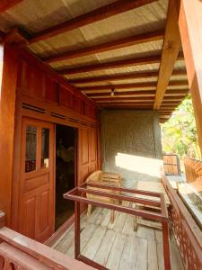 a porch of a house with a bench and a door at Villa Kamar Tamu Bangunjiwo in Ngingas