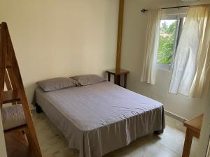 a small bedroom with a bed and a window at Los Amores Apartments A in Pérula