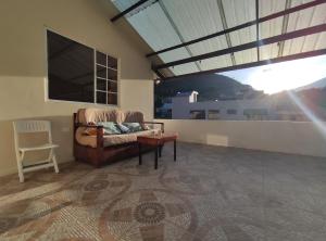 uma sala de estar com um sofá e uma grande janela em Apartamento "ROOFTOP view 360" em Baños