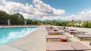 a swimming pool with tables and benches next to a pool at Viewpoint Condominiums in Pigeon Forge