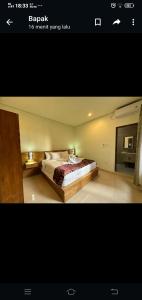 a bedroom with a bed with two lamps on it at Apartment Wayan in Canggu