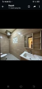uma casa de banho com um lavatório, uma banheira e um WC. em Apartment Wayan em Canggu