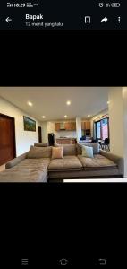 een slaapkamer met een groot bed en een bank bij Apartment Wayan in Canggu