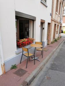 una mesa y dos sillas sentadas fuera de un edificio en La Maison d'Yvonne, en La Bouille