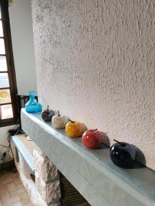 a row of different colored tomatoes sitting on a mantle at La Maison d'Yvonne in La Bouille