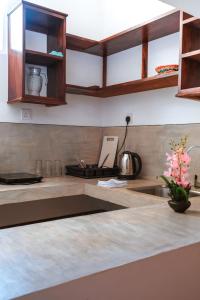 una cocina con armarios de madera y fregadero en Lawrence Villa en Weligama