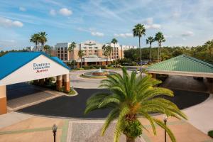 a resort with a palm tree in front of a building at Courtyard by Marriott Orlando Lake Buena Vista in the Marriott Village in Orlando