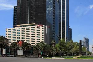 un grand bâtiment avec des palmiers dans une ville dans l'établissement Mexico City Marriott Reforma Hotel, à Mexico