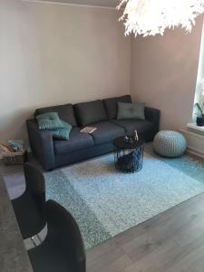 ein Wohnzimmer mit einem Sofa und einem Tisch in der Unterkunft Kaski, three-room condo in a prime location, free parking in Tampere