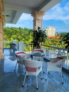 un patio con mesas y sillas en el balcón en Phượng Hoàng villa en Ha Long