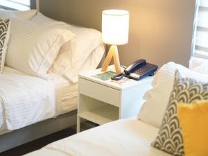 ein Schlafzimmer mit einem Bett und einem Telefon auf einem Nachttisch in der Unterkunft Emerald Manor Hotel in Kababae