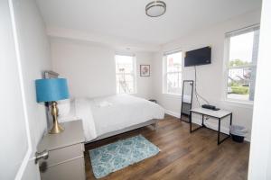 a white bedroom with a bed and a blue lamp at The Oasis ;Luxury and Style in Washington