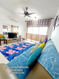 a bedroom with a large bed with a blue blanket at Cityview Homestay Seksyen 13 Shah Alam, Aeon Mall, Stadium, I-City in Shah Alam
