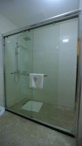 a glass shower stall with a white towel on it at Triple E Hotel and Spa in Addis Ababa