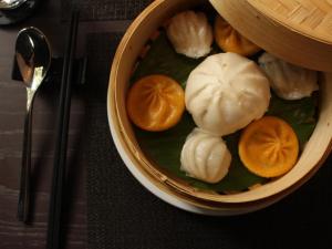 a bowl of food with peeled oranges and dumplings at The Bloom Classic - Hotel and Bistro in Hanoi