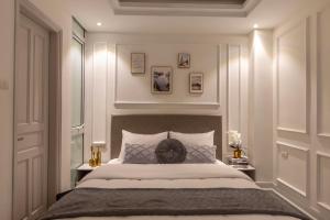een slaapkamer met een groot bed met witte muren bij Keypad Hotel - 87 Nguyễn Khang in Hanoi