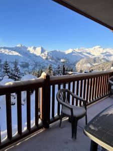 einen Balkon mit einem Tisch und einem Stuhl sowie schneebedeckten Bergen in der Unterkunft Résidence Le Roselend - maeva Home - Appartement 3 Pièces 6 Personnes - Sé 82 in Bourg-Saint-Maurice