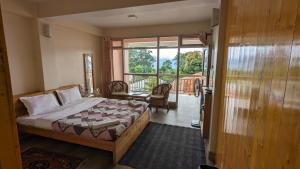 a bedroom with a bed and a view of a balcony at Shikher in Kalimpong