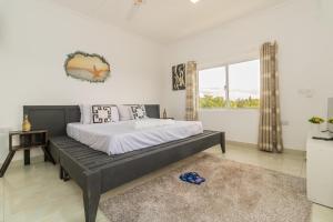 a bedroom with a large bed and a window at Chameleon house diani in Ukunda